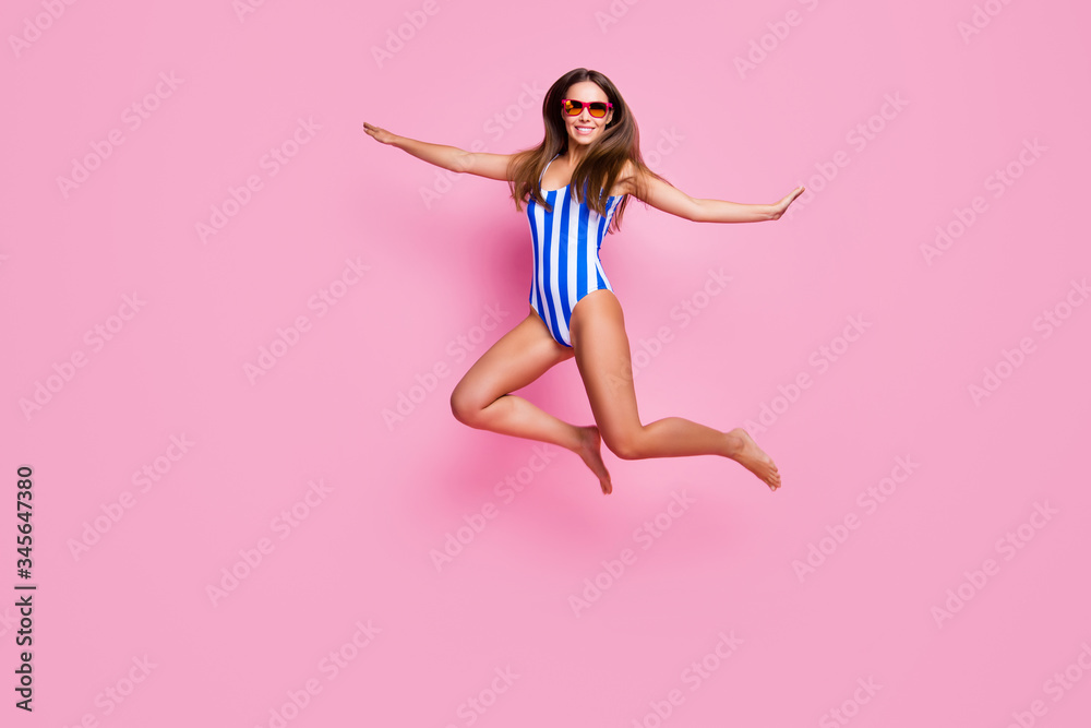 Full body photo of crazy hot figure lady fit legs perfect long straight hairdo jumping high into sea ocean water wear sun specs striped bodysuit isolated pastel pink color background