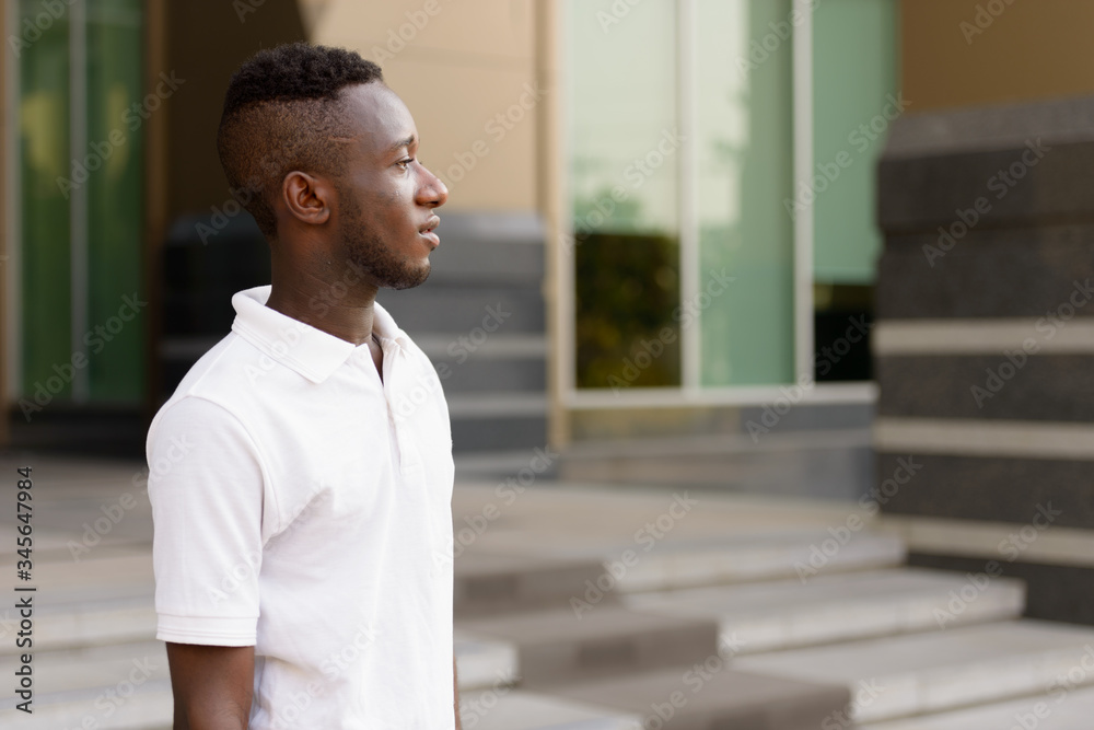 Profile view of young African man in the city outdoors Profile view of young African man in the city outdoors