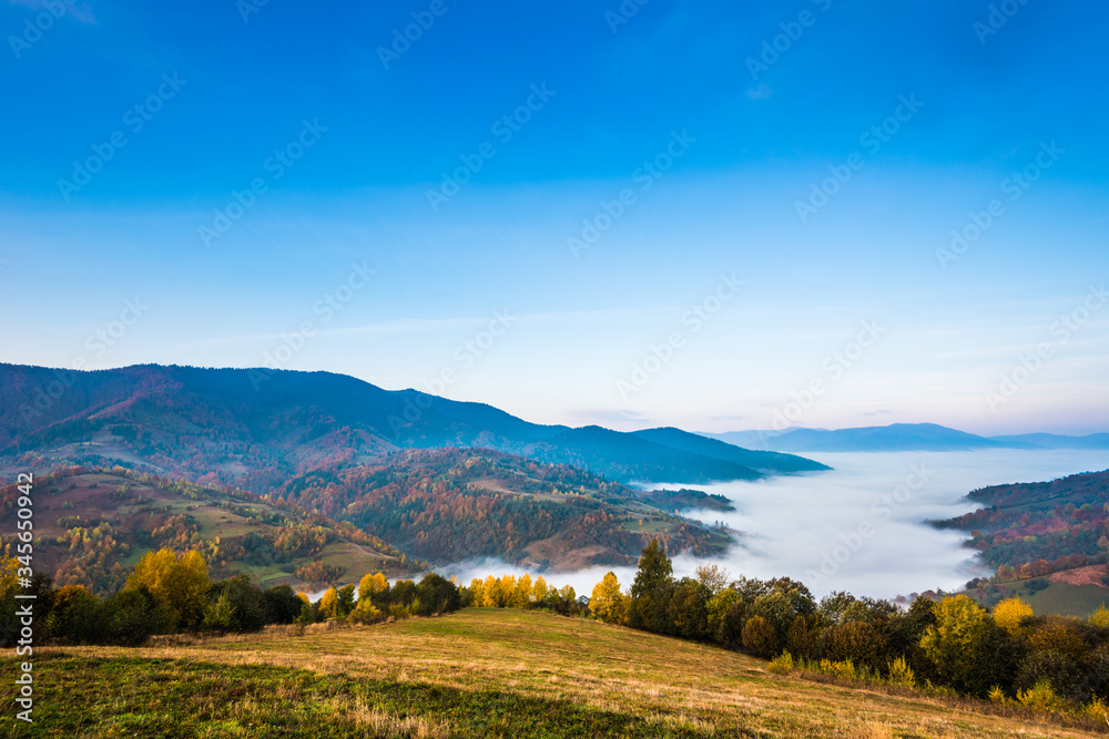 Fototapeta premium Beautiful morning landscape with autumn foggy mountains.