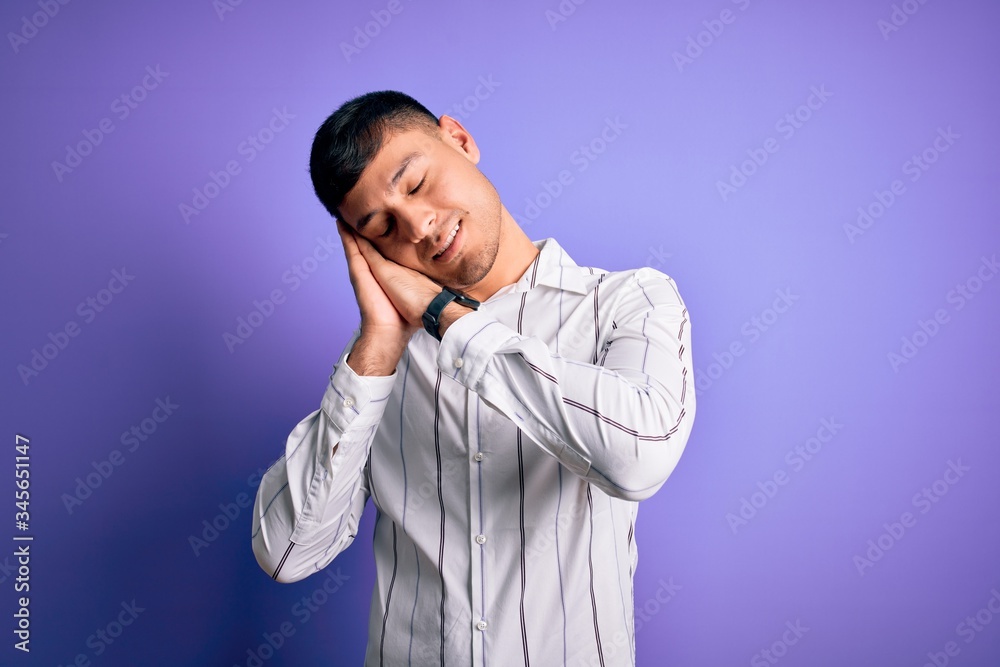 Young handsome hispanic man wearing elegant business shirt standing over purple background sleeping tired dreaming and posing with hands together while smiling with closed eyes. Young handsome hispanic man wearing elegant business shirt standing over purple background sleeping tired dreaming and posing with hands together while smiling with closed eyes.