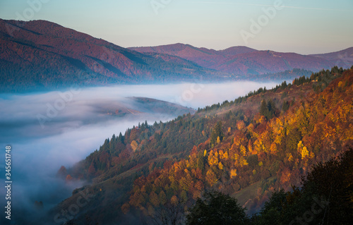 Beautiful morning landscape with autumn foggy mountains.