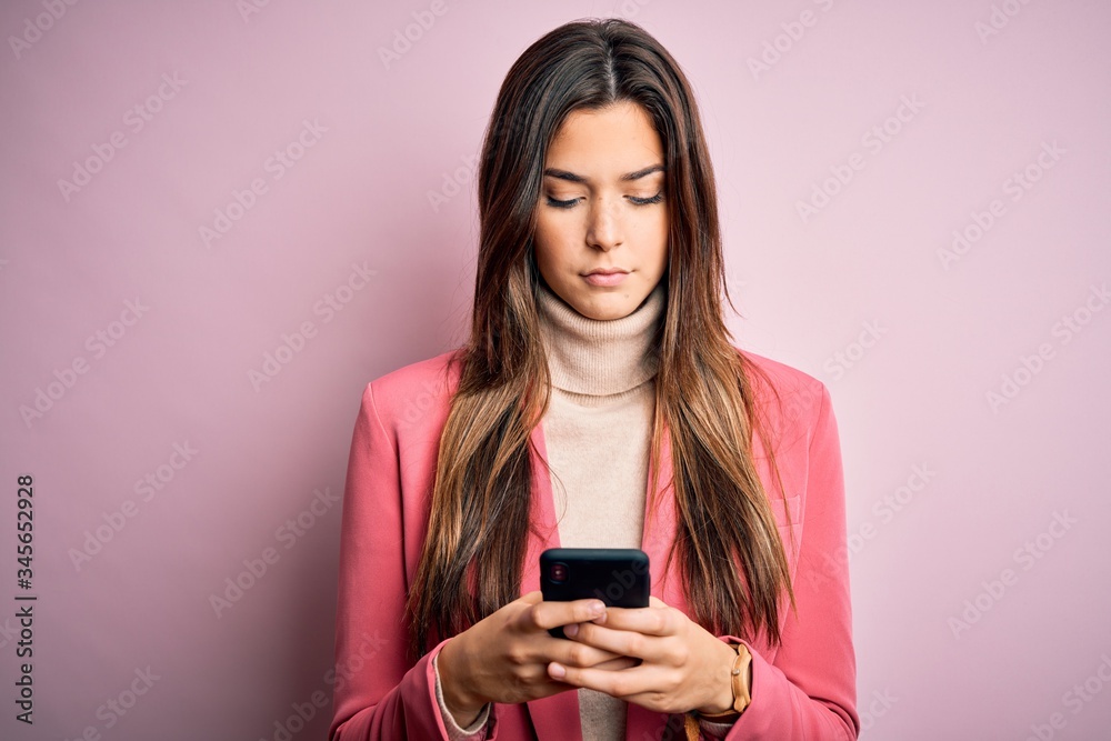Young beautiful girl having conversation using smartphone over white background with a confident expression on smart face thinking serious