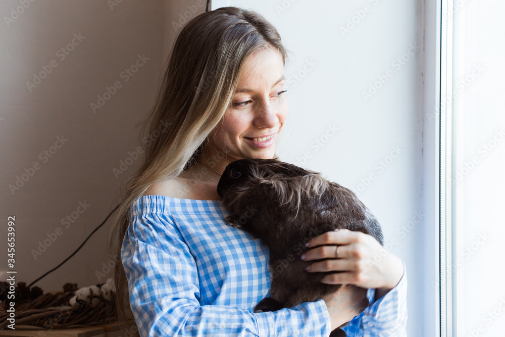Pet and Easter concept - Happy girl hugging brown rabbit at home. Pet and Easter concept - Happy girl hugging brown rabbit at home.