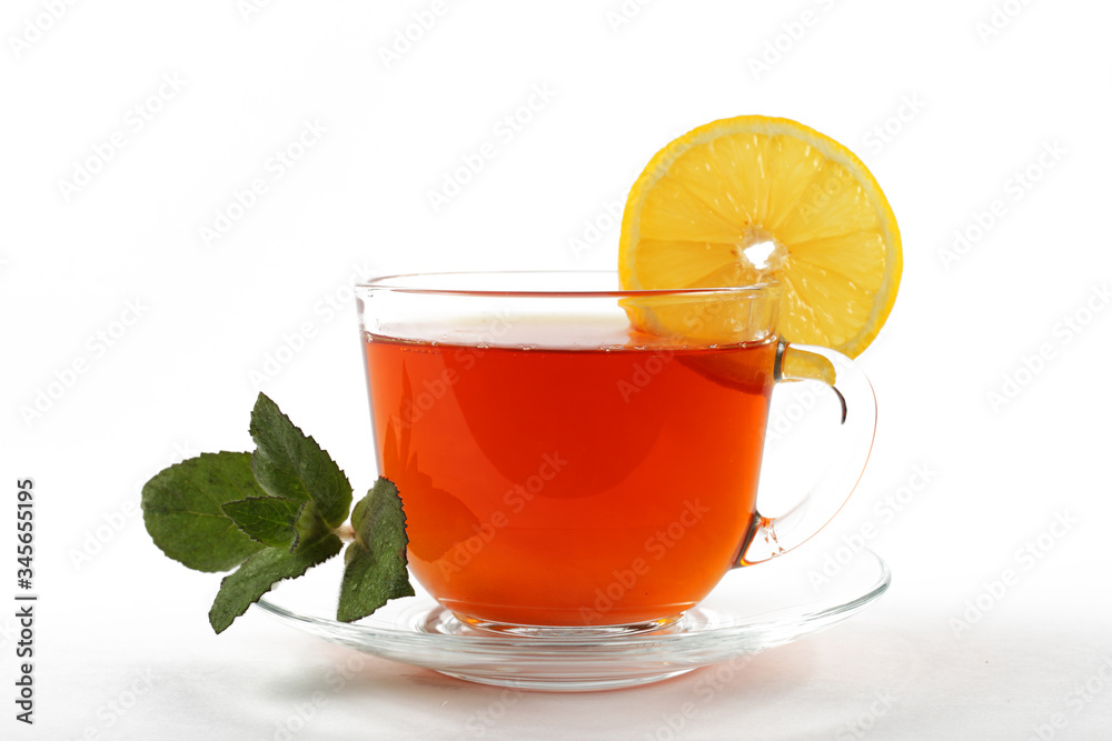 glass mug of tea with mint leaves and lemon, white background, isolate