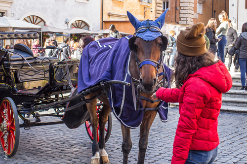 Rome, 10.11.2019, a girl reaches out to a horse in Sunny weather on the square of the temple of all the Gods-the Pantheon © Alexnow