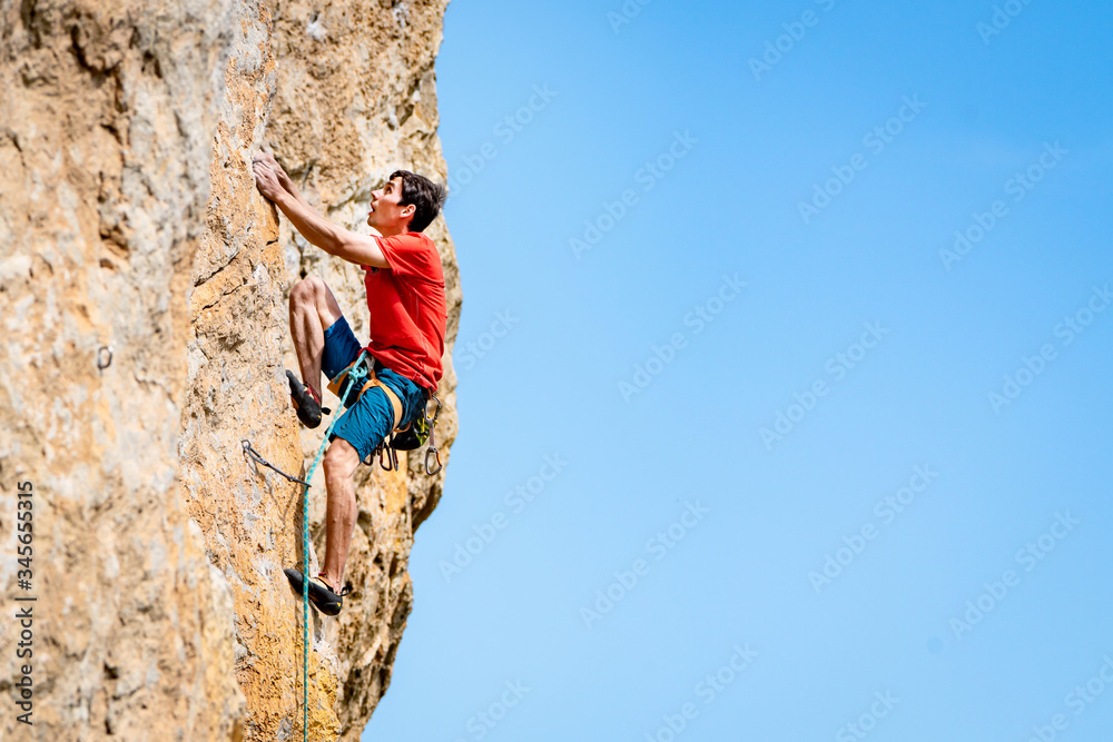 Fototapeta premium Man climbs a rock.