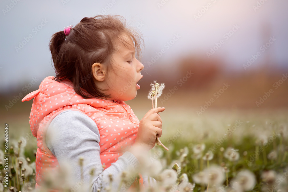 Cute little girl on the meadow in spring day
