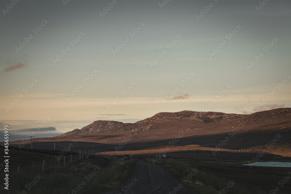 Rural Road Across Scottish Highlands at Sunset