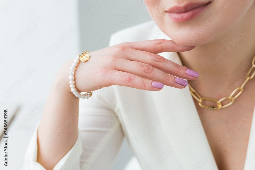 Close-up of woman wearing a gold necklace and bracelet. Jewelry, bijouterie  and accessories concept. Stock Photo | Adobe Stock