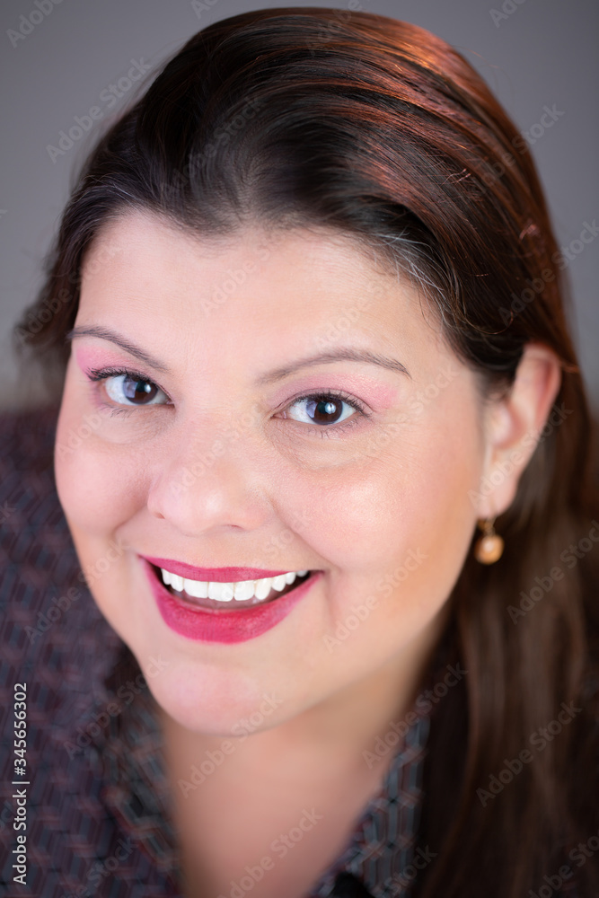 Closeup portrait of a caucasian lady. She is looking up at the camera. She is smiling. Closeup portrait of a caucasian lady. She is looking up at the camera. She is smiling.