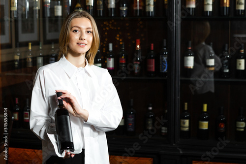 Vászonkép Young pretty girl sommelier serving & presenting bottles of red and white of wine