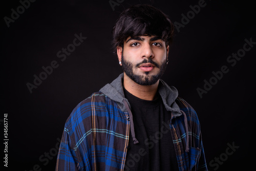 Portrait of young handsome bearded Indian hipster man