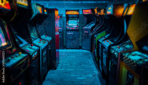 Fotografiet Arcade video games in an empty dark gaming room with purple light with glowing v