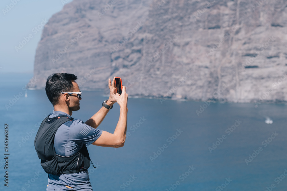 man taking photos of sunset with mobile phone man taking photos of sunset with mobile phone