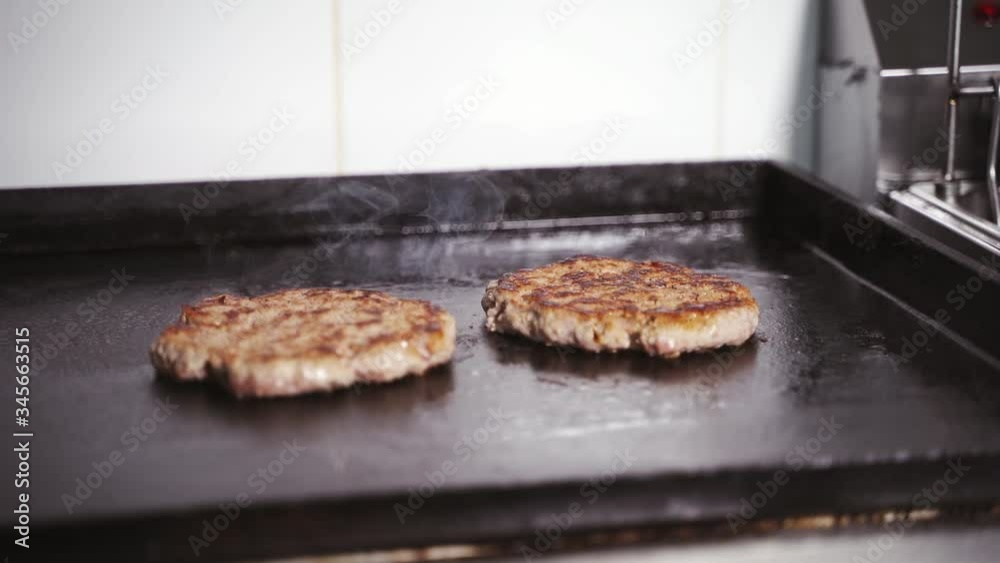 two meat patties for burger are fried in a pan two meat patties for burger are fried in a pan
