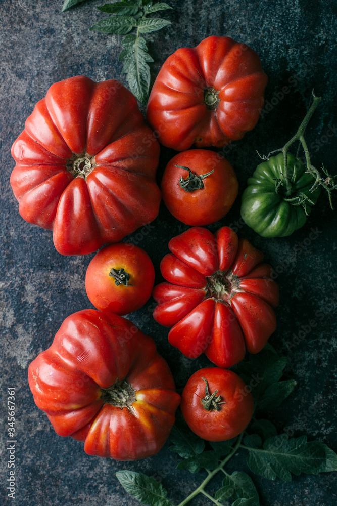Fresh, ripe tomatoes on dark metal background. Fresh, ripe tomatoes on dark metal background.