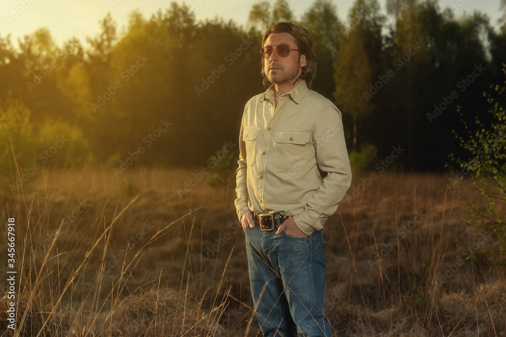 Man in shirt and sunglasses in nature at sunrise during spring. Man in shirt and sunglasses in nature at sunrise during spring.