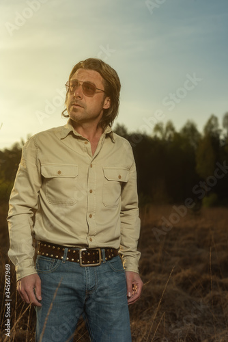 Man in shirt and sunglasses in nature reserve at sunrise during spring. © ysbrandcosijn