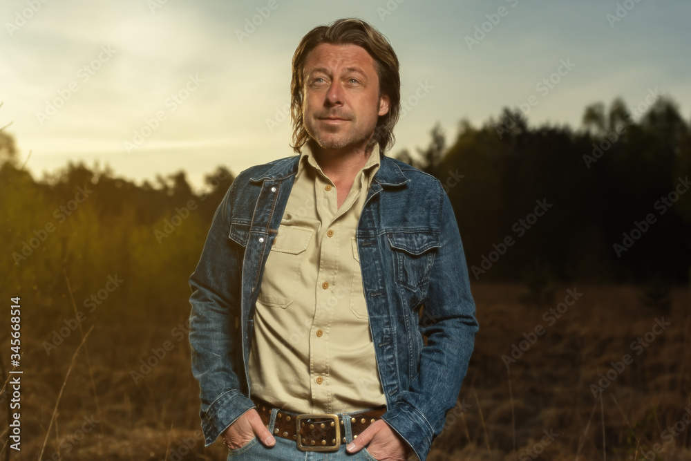 Man in denim jacket and shirt in nature reserve at sunrise during spring. Man in denim jacket and shirt in nature reserve at sunrise during spring.