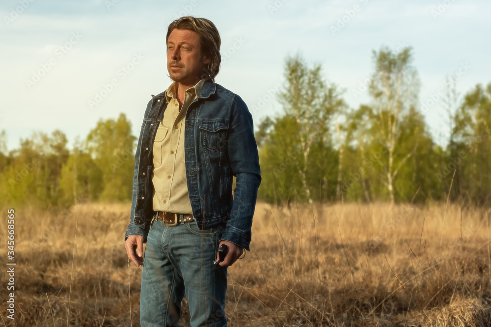 Man in jeans jacket and shirt in nature reserve at sunrise during spring. Man in jeans jacket and shirt in nature reserve at sunrise during spring.