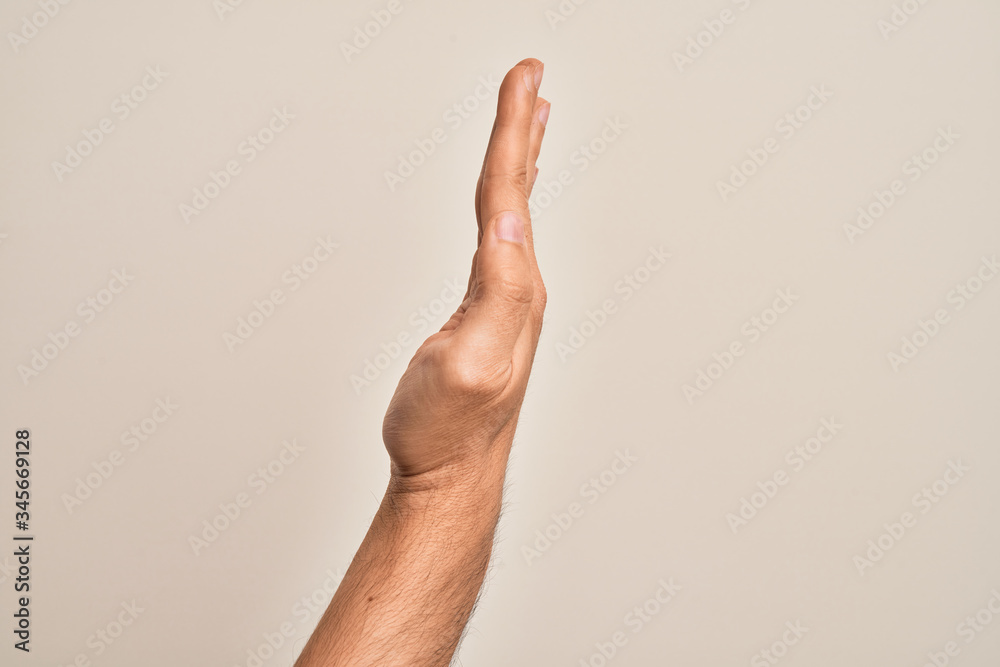 Hand of caucasian young man showing fingers over isolated white background showing the side of stretched hand, pushing and doing stop gesture Hand of caucasian young man showing fingers over isolated white background showing the side of stretched hand, pushing and doing stop gesture