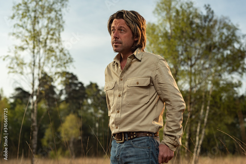 Man in light brown shirt in nature reserve at sunrise during spring.