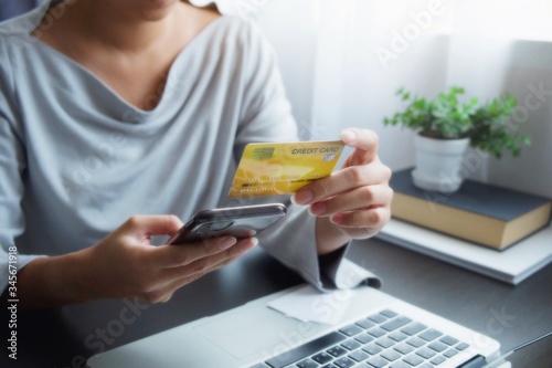 Hands of Asian woman holding a credit card and typing, slide, press, touch screen of mobile phone for operation of internet banking transaction or transfer money, order or buy product, shopping online