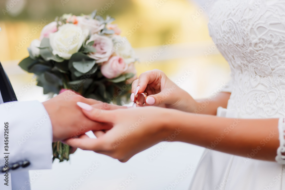 Wedding ceremony. The bride don the wedding ring on the groom's finger. Love and marriage. Wedding ceremony. Man and woman in wedding dress. Closeup view married couple.