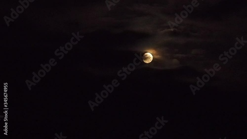 Passing clouds cover the moon in the sky. Night shooting