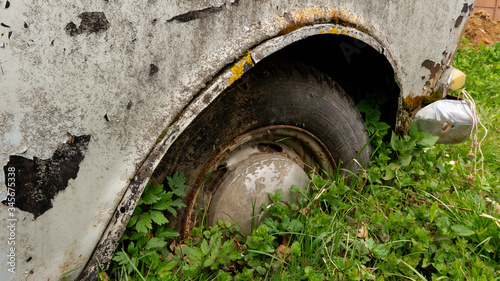 abandoned retro car overgrown with moss. wheels overgrown in the ground. cemetery of cars. Muscovite.