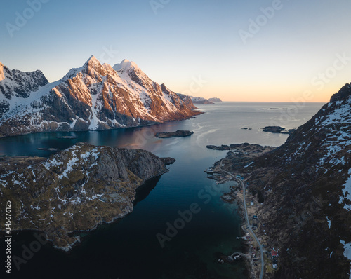 Aerial picture of a fjord in north of norway. Located in the Lofoten islands. Snowy mountains during sunset. Soft sunset light and beautiful landscape. 