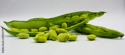 panoramic of open green broad beans in their shells and some shelled beans isolated on a white background photo