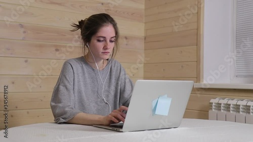 A young businesswoman works from home during quarantine, writes a letter to colleagues in a working chat 