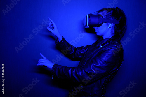 Girl wearing virtual reality glasses touches the air with her finger