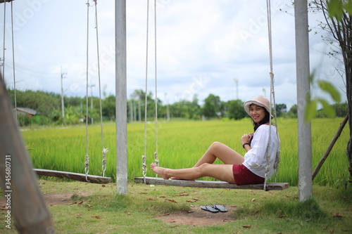 Woman sitting on a swing in a rice field Rayong, Thailand