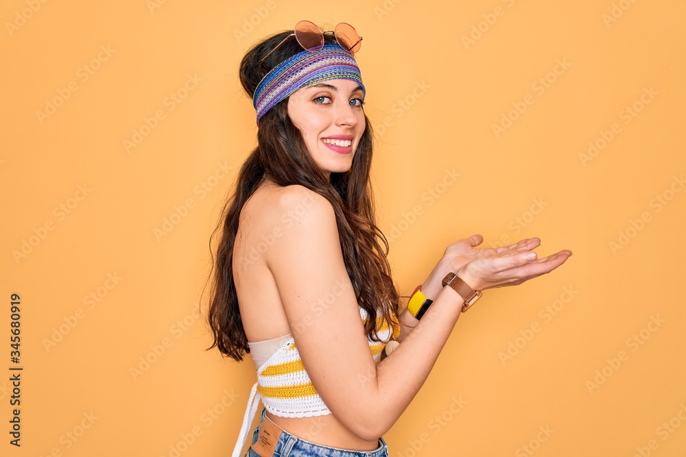 Young beautiful hippie woman with blue eyes wearing accesories and sunnglasses pointing aside with hands open palms showing copy space, presenting advertisement smiling excited happy Young beautiful hippie woman with blue eyes wearing accesories and sunnglasses pointing aside with hands open palms showing copy space, presenting advertisement smiling excited happy