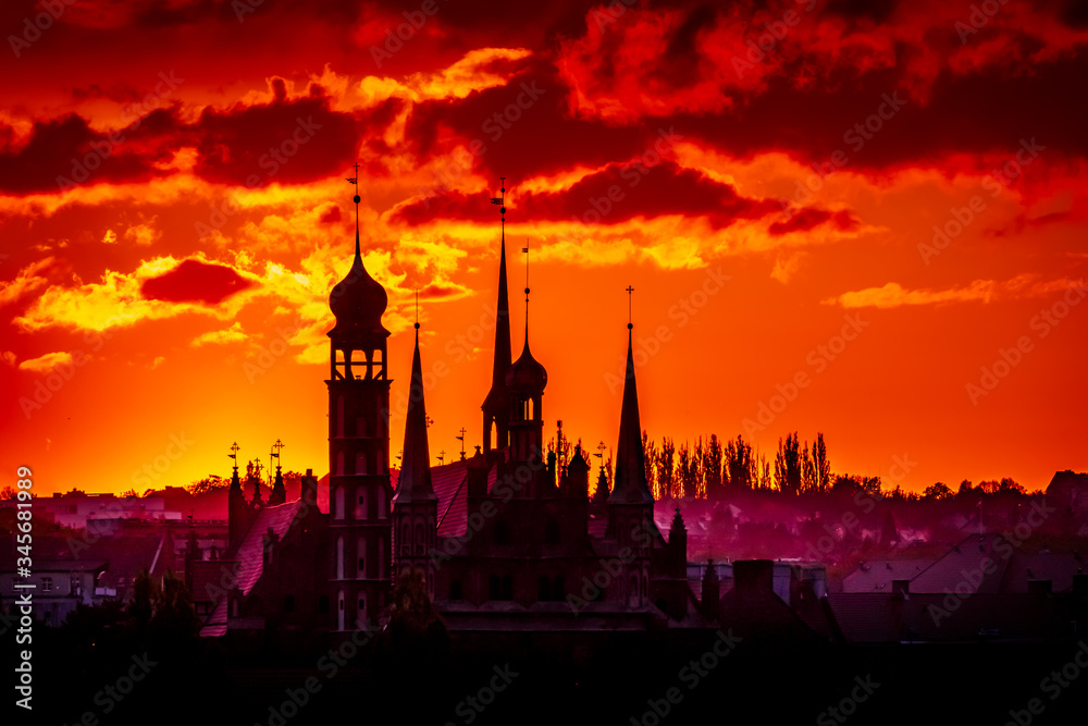 Naklejka premium Astonishing red and orange sunset over Gdansk, Poland with silhouette of the cathedral