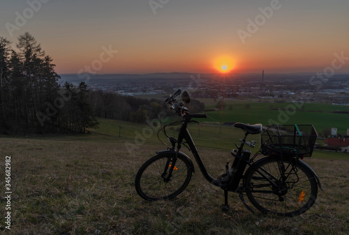 Black electric bike on ski slope in Budweis city with sunset
