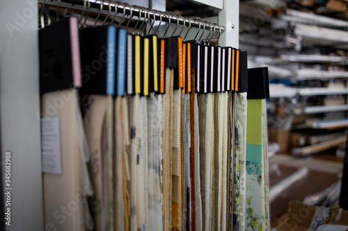 Colorful curtain samples hanging from hangers on a rail in a display in a retail store photo