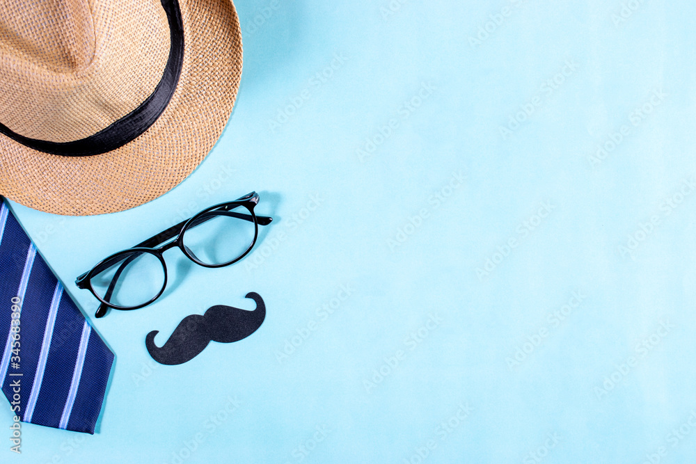 Happy fathers day concept. Top view of blue tie, beautiful gift box, man hat with glasses and mustache on bright blue pastel background. Flat lay - obrazy, fototapety, plakaty 