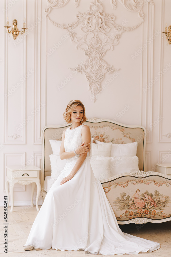 Fototapeta premium Portrait of the bride. Young girl, blonde with a short haircut. Full growth plan, vintage. Posing beautifully.