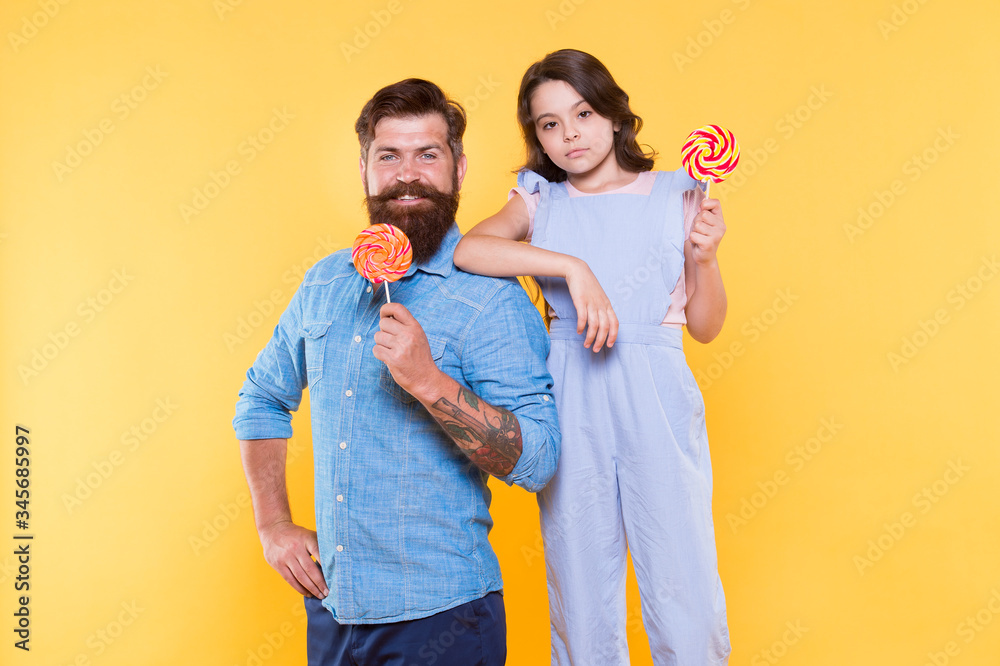 Obraz premium When children seem hard to please. Daughter and father eat sweet candy. Bearded man and cute sweet baby. Loving daddy and small girl eating lollipop. Summer vacation. Happy holidays. Sweet childhood