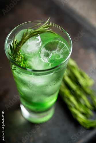 Sweet tequila based green cocktail with tarragon and rosemary. Selective focus. Shallow depth of field.