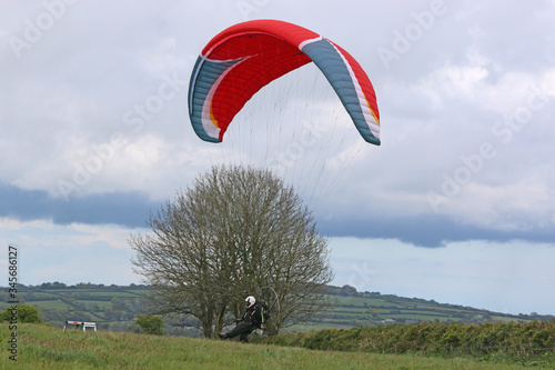 Paramotor pilot landing in a field