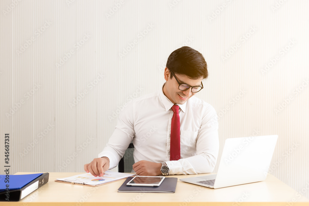 Young employee looking at laptop computer screen during working day in office with happiness. Businessman working on laptop computer for project and analyzing documents of business that get successful Young employee looking at laptop computer screen during working day in office with happiness. Businessman working on laptop computer for project and analyzing documents of business that get successful
