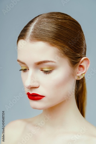 Portrait of attractive sexy woman with red lips posing grey background. Beautiful healthy face of the young pretty woman with fresh skin.