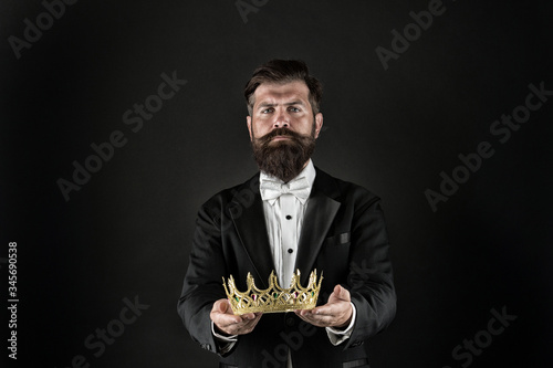 Reputation and status. Glory and ambitions. King crown. Royal coronation symbol. Now come and make it worth. Crown in hands. Handsome man give crown black background. Getting reward. Crowning glory
