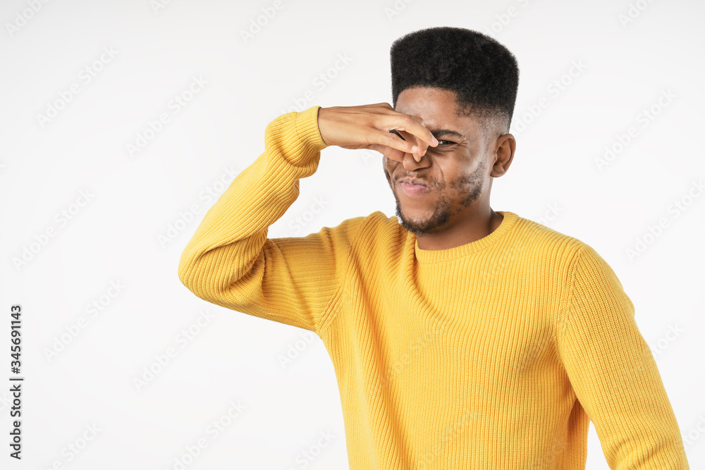 Young african man with bad smell expression over white background Young african man with bad smell expression over white background
