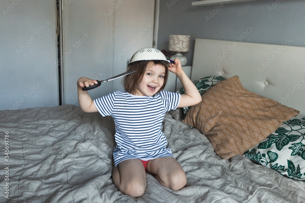 Funny girl child cuts her hair with on head