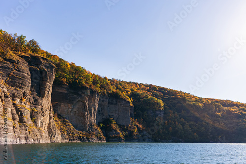 river and rocks on the shore covered with autumn forest. view fr